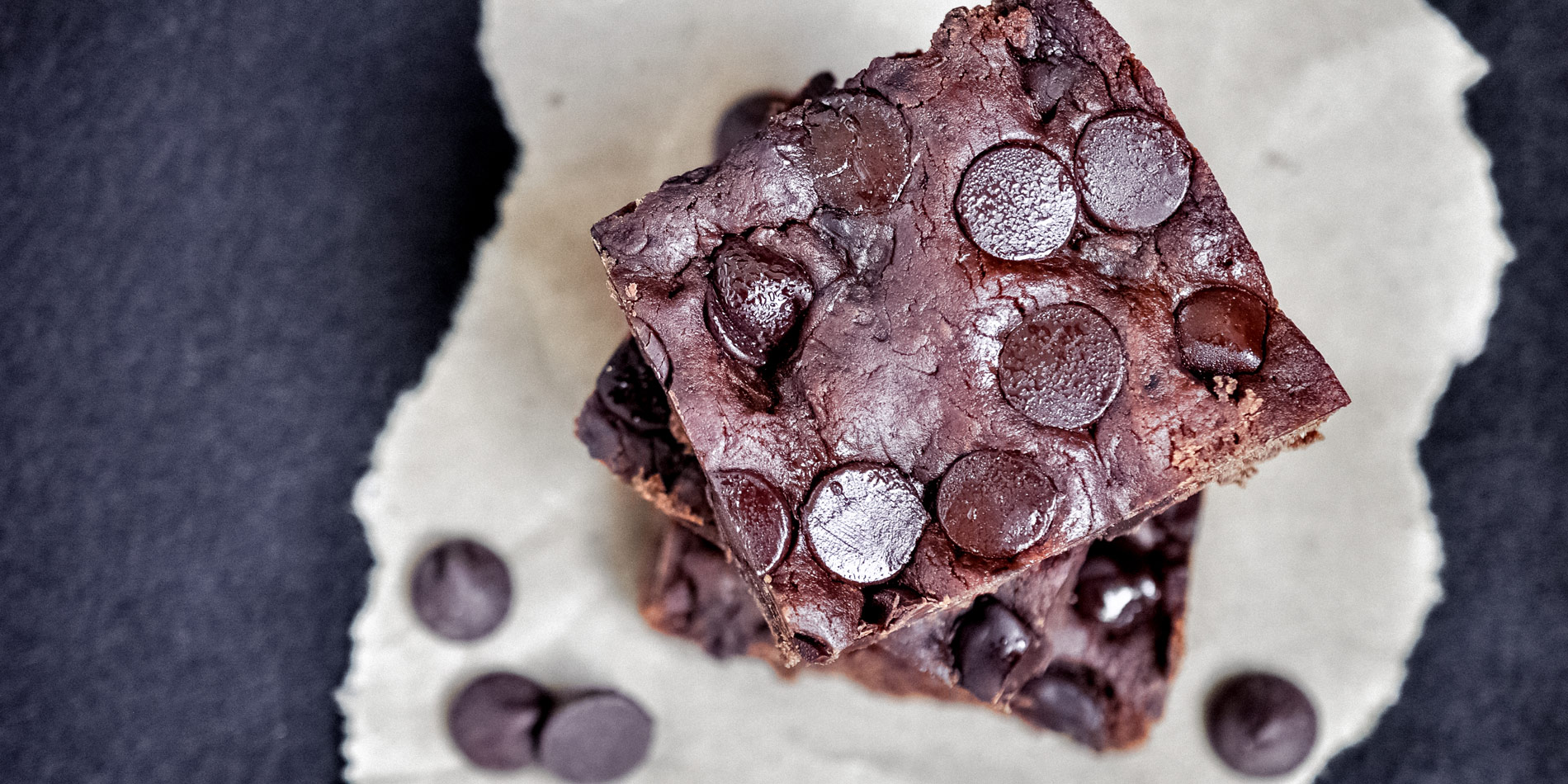 Gluten Free Chocolate Hazelnut Brownies stacked up and closeup in bird's eye view on black background