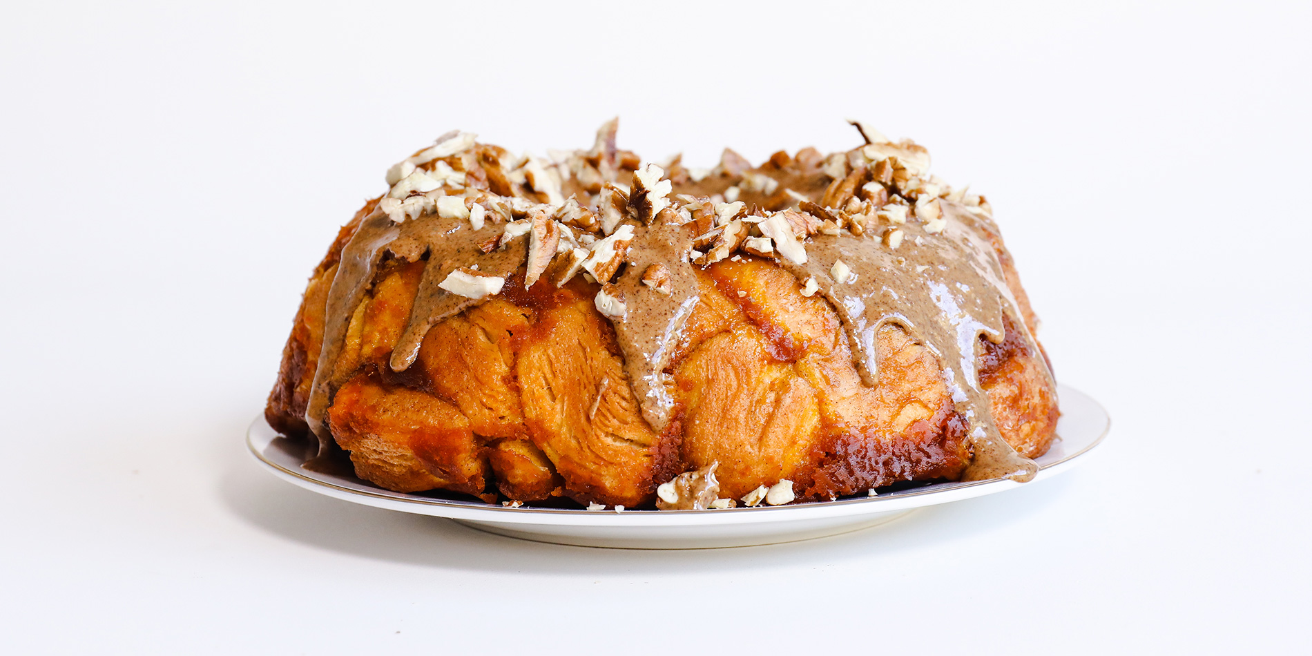 Maple Pumpkin Monkey Bread on a white plate on a white background (side view)