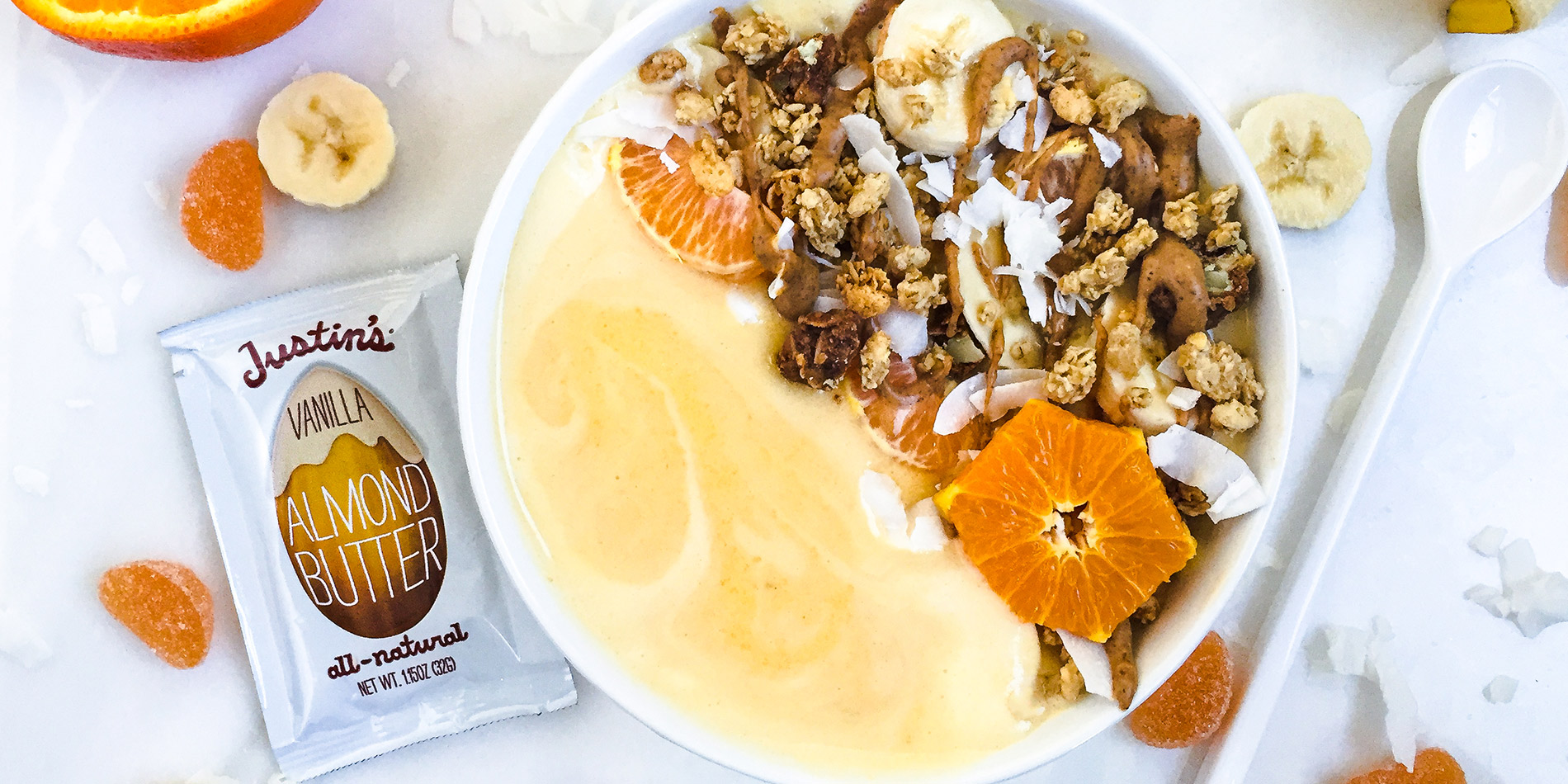 Orange Creamsicle Smoothie Bowl with a sliced orange & banana, with scattered banana slices, orange jelly, and coconut flakes