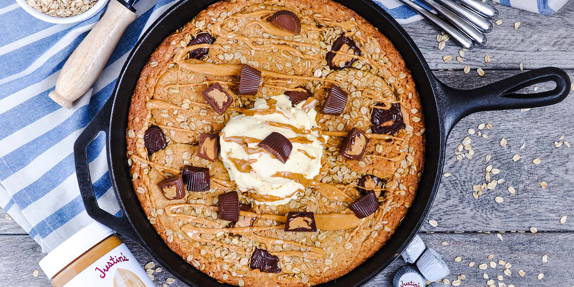Peanut Butter Cup Oatmeal Skillet Cookie on cloth with oatmeal flakes in a bowl and scattered on a gray wooden background
