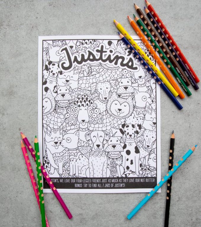 Justin's free printable coloring page with line art of dogs with colored pencils laid out on a grey textured background