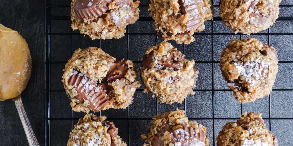 4-Ingredient Peanut Butter Banana Oatmeal Cookies on a black cooling tray with a spoon on a grainy textured background
