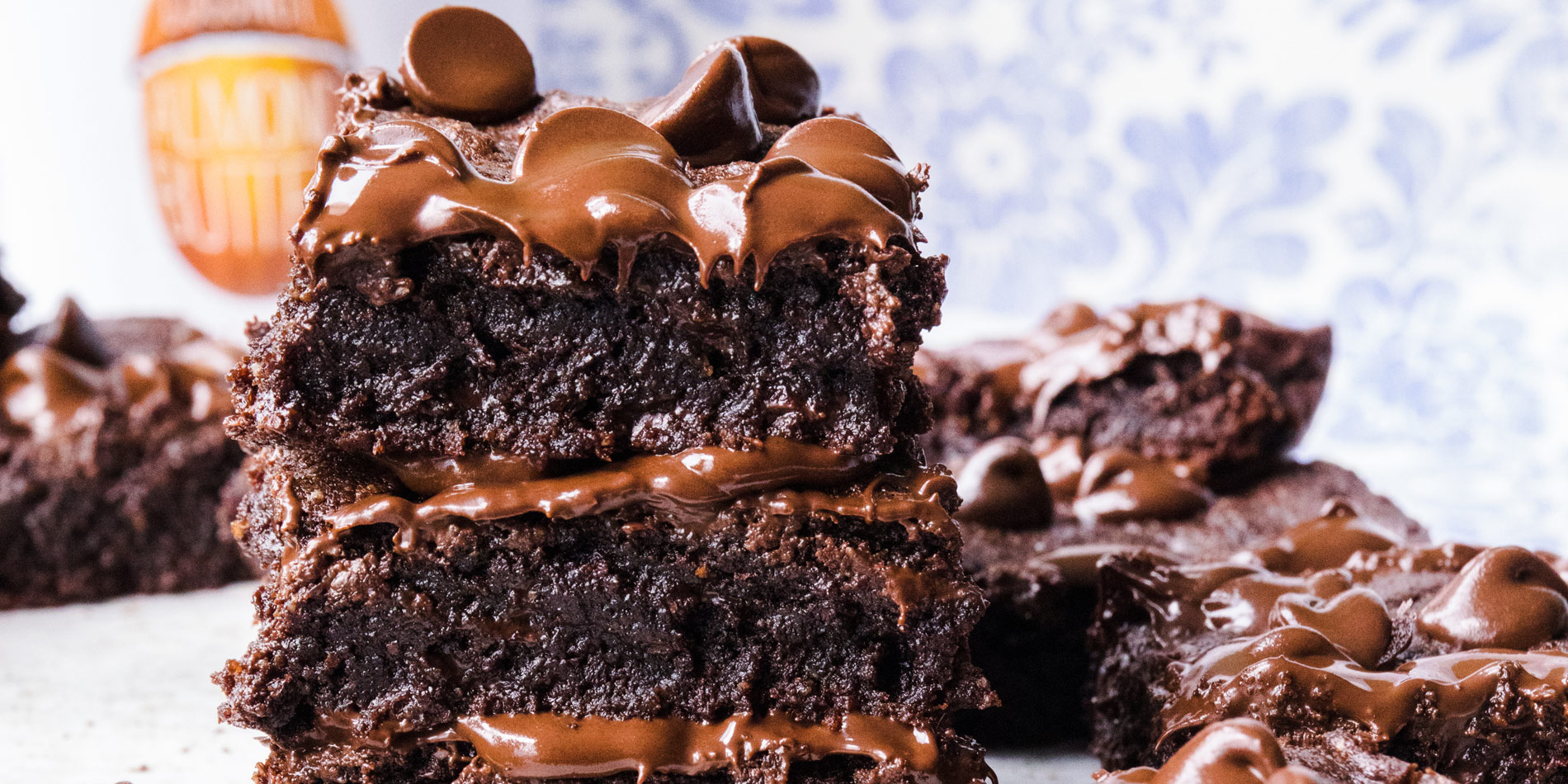 Fudgy Gluten Free Quinoa Flour Brownies stacked and placed beside each other in floral print background (close up shot)