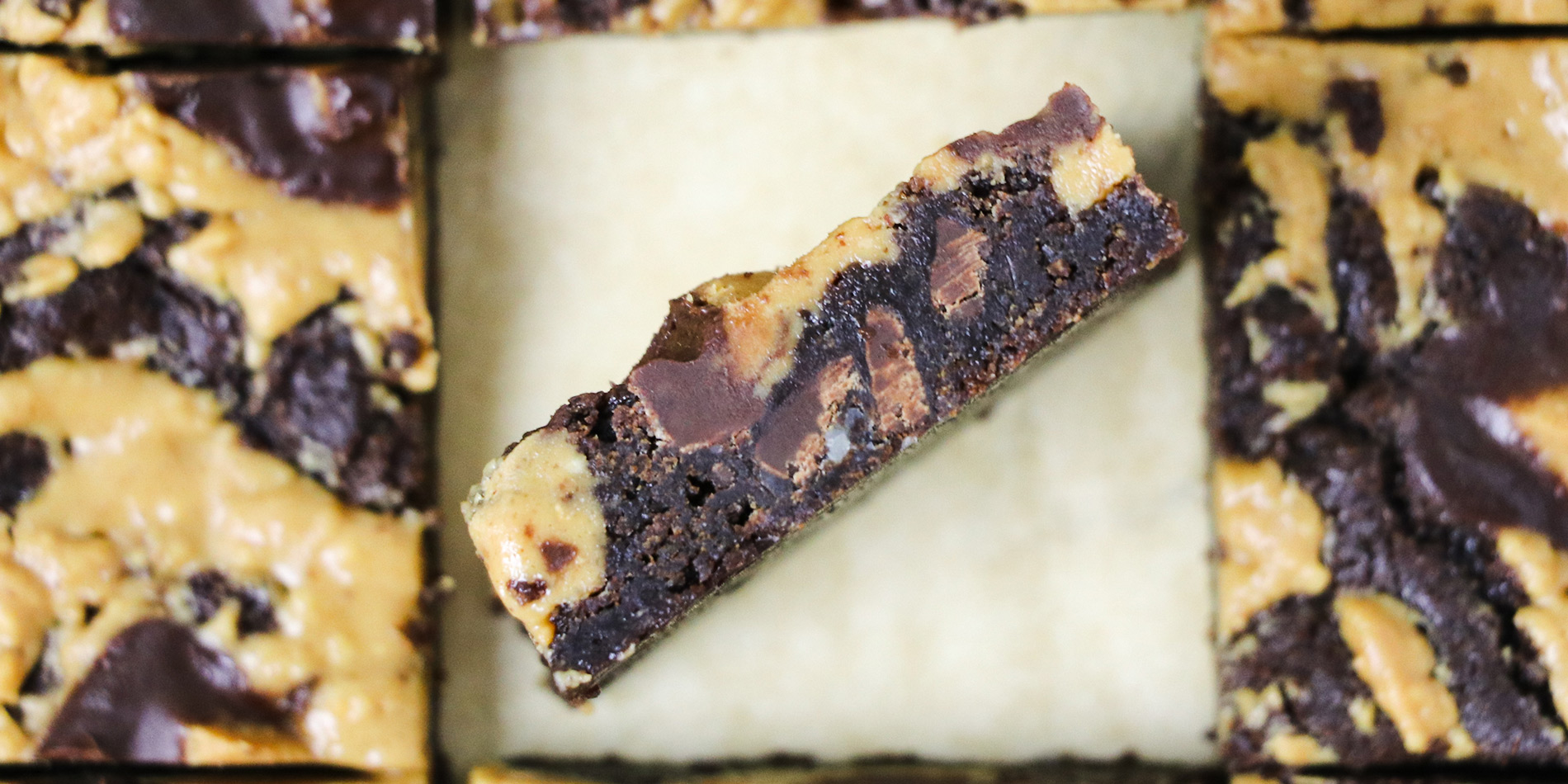 Peanut Butter Cup Brownies with one diagonal slice showing the side in the center of 8 pieces shown from top view of brownies