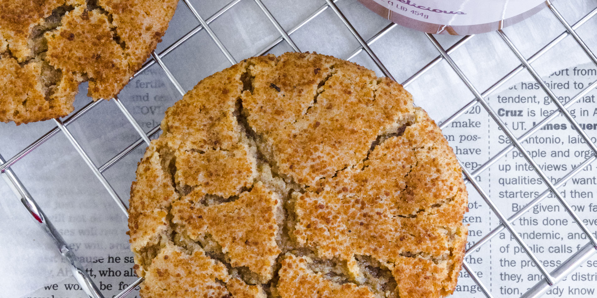 Honey Peanut Butter Miso Cookies on a cooling rack on top of newspaper print parchment paper (close up shot)