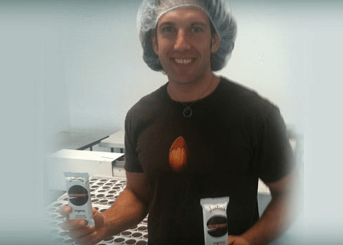 Justin with a hairnet, holding Justin's nut butter cup in each hand
