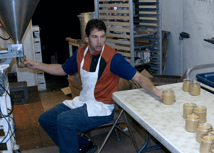 Justin sitting on chair, producing Justin's peanut butter products