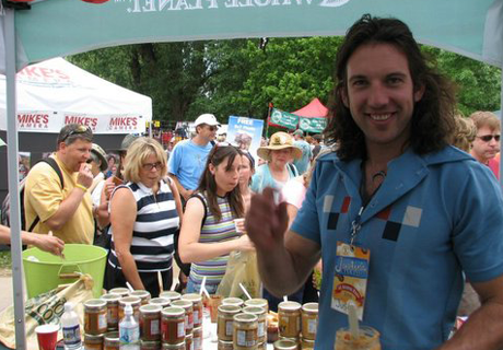 Justin standing under a festival stall with many people in the background