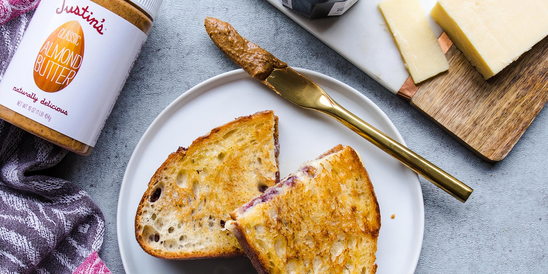 Almond Butter Blueberry Cheddar Melt on a ceramic plate with a gold butter knife