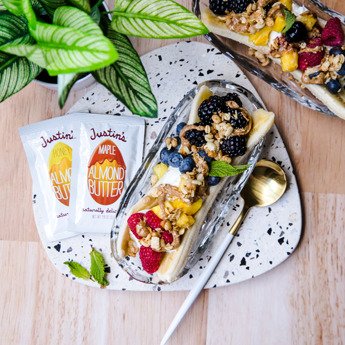 Banana split with peanut butter, fruit and granola on top.