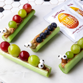Celery sticks with peanut butter, grapes and blueberries on top.
